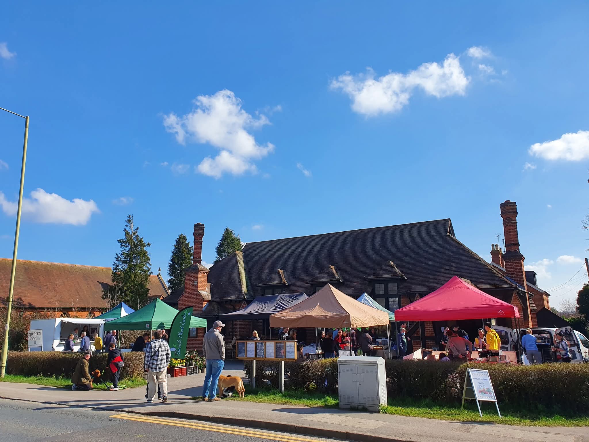 Market stalls under gazebos outside Spencers Wood Village Hall on a sunny day